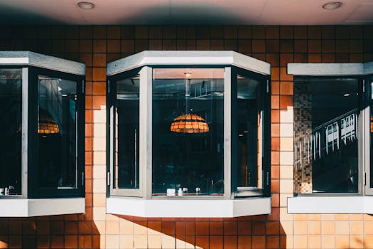 Modern bay windows with natural light and geometric brick pattern, featuring hanging lamp.